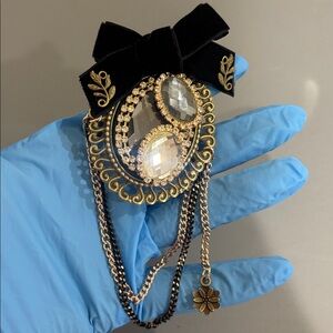 Elegant Black and Gold Brooch with Chains